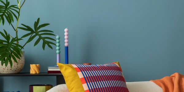 Colorful cushions on a couch with a blue wall background.