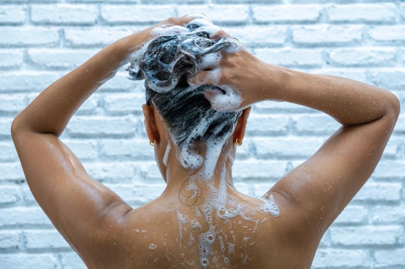 Beautiful woman's hand She was washing her hair and nourishing her scalp. Shampoo and conditioner