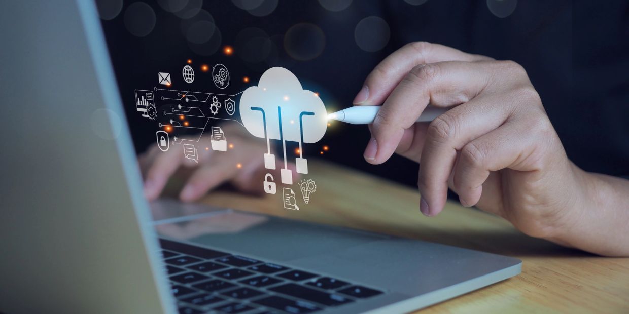 Person using stylus with holographic cloud computing icons over laptop.