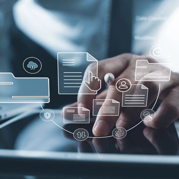 Person interacting with digital document icons on a tablet next to a laptop.