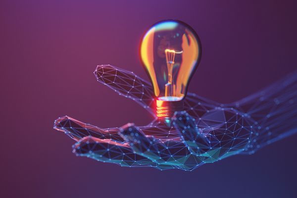 Digital hand holding a glowing light bulb symbolizing innovation and ideas.