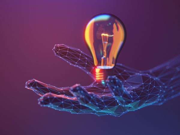 Digital hand holding a glowing light bulb symbolizing innovation.