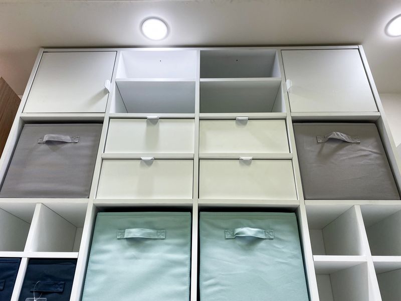 This sleek vertical shelf, complete with colorful bins, provides an elegant and highly functional solution for efficiently organizing any modern home or office space in a stylish manner