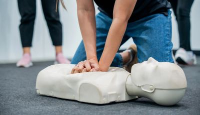 Person practicing CPR on a manikin.