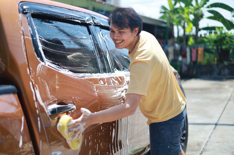 Man taking care of car, cleaning and polishing car