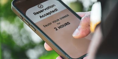 Phone screen showing a dinner reservation confirmation for 2 hours.