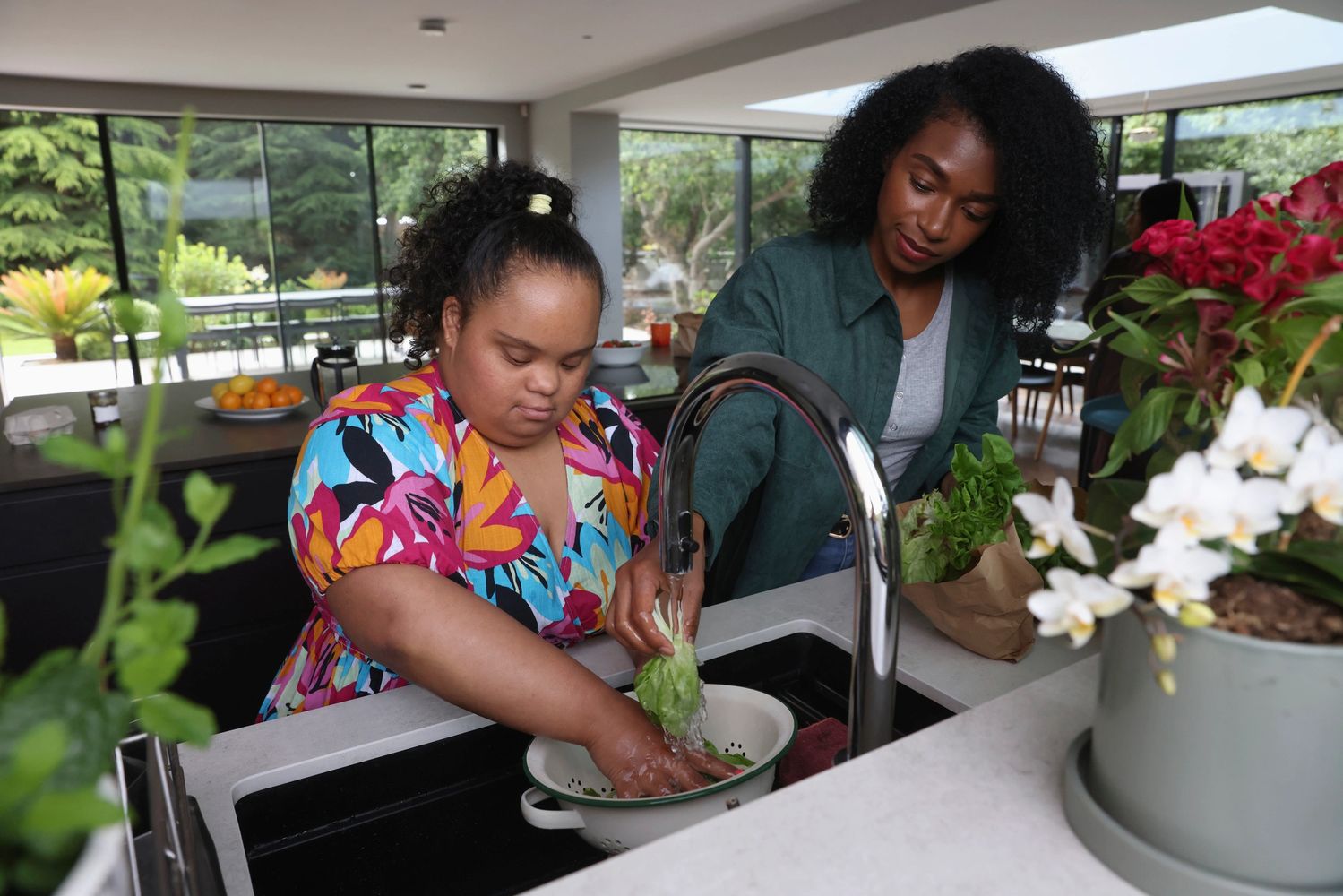 A woman lets her daughter wash vegetables