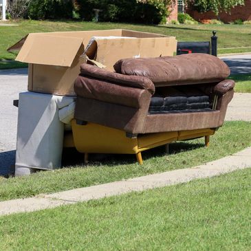 Discarded sofa and boxes by the roadside.