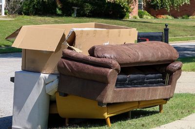 Discarded furniture and cardboard boxes left by the roadside.