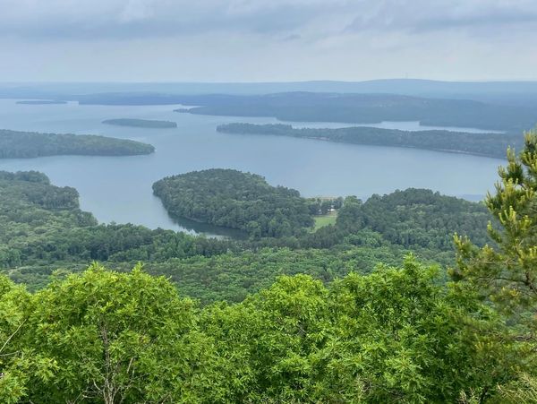 Scenic view of a lake surrounded by forested islands and hills.