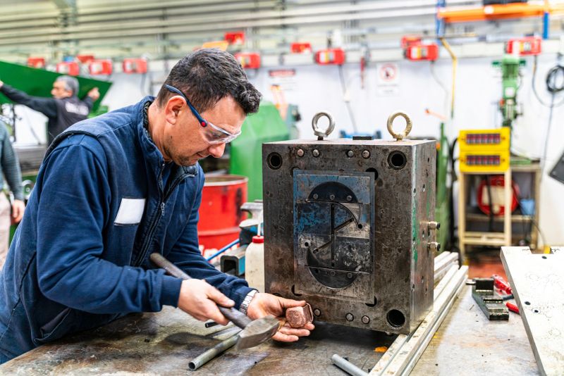 Industry engineer worker wearing safety uniform control operating computer controlled Lathe grinding machine working in industry factory is metal manufacturing industry concept.