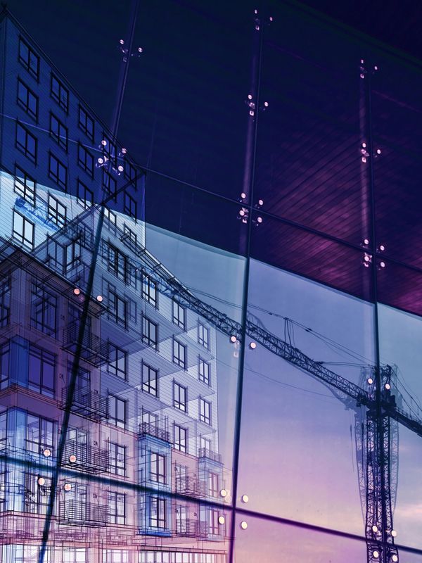 Reflection of a building and crane on tinted glass panels at dusk.