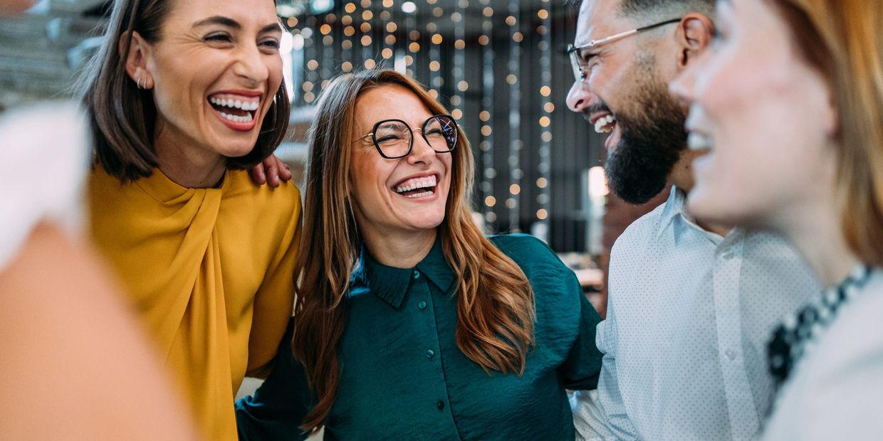 A group of friends laughing and enjoying a moment together indoors.