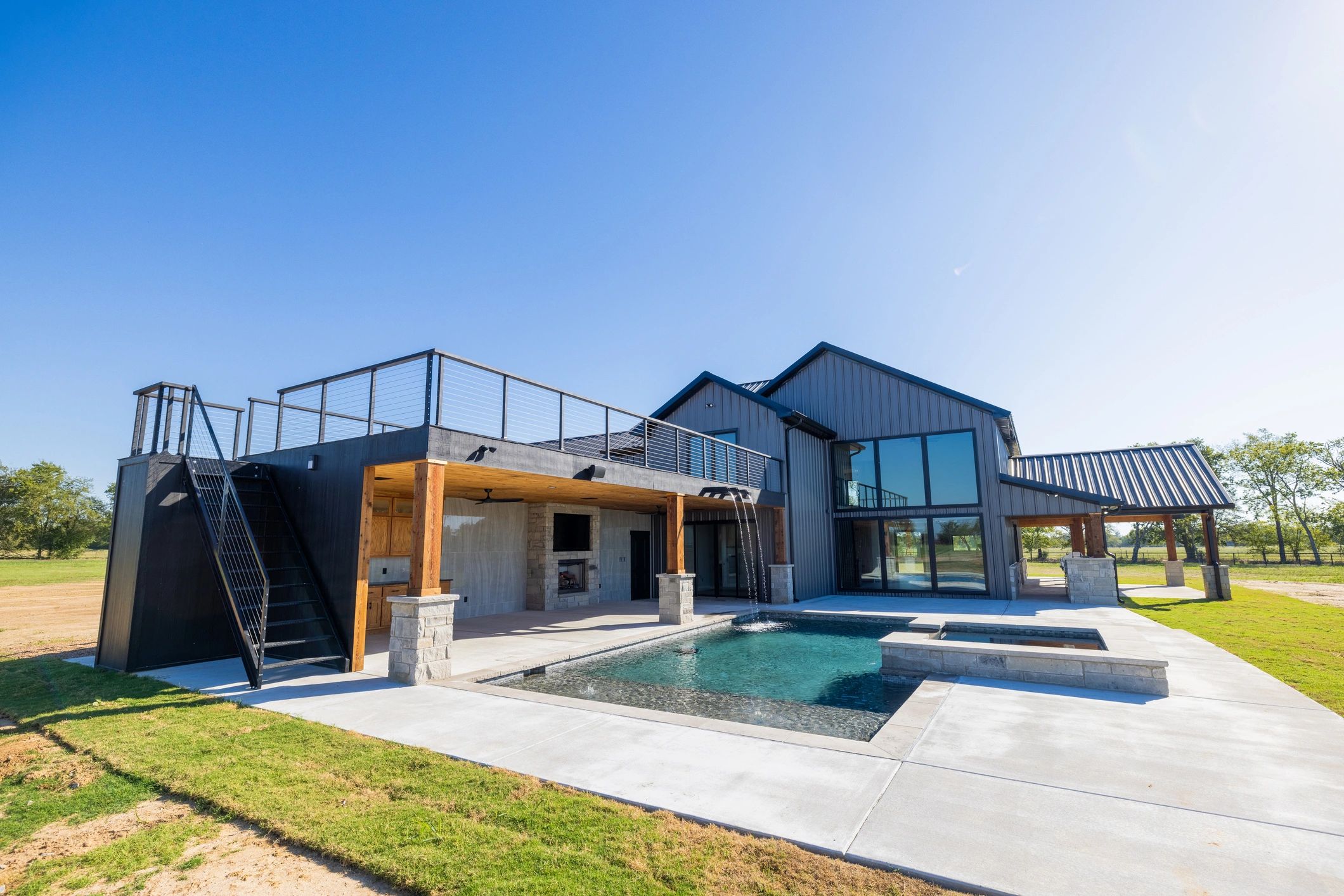 Modern house with pool and rooftop terrace under clear sky.