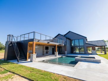 Modern house with flat roof, pool, and deck.