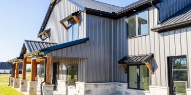 Modern metal house exterior with stone accents.