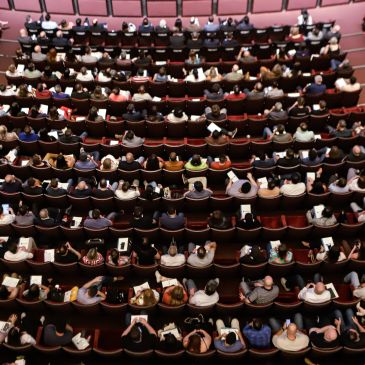 Overhead view of a full audience seated in a theater or auditorium.