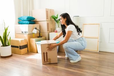 girl lifting a box using the correct manual handling techniques to prevent injury 