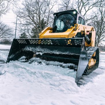 Yellow bulldozer clearing snow.