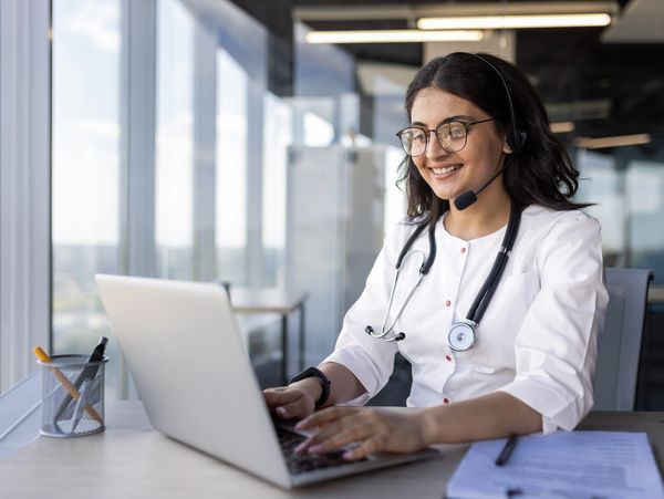 Professional on phone using laptop.