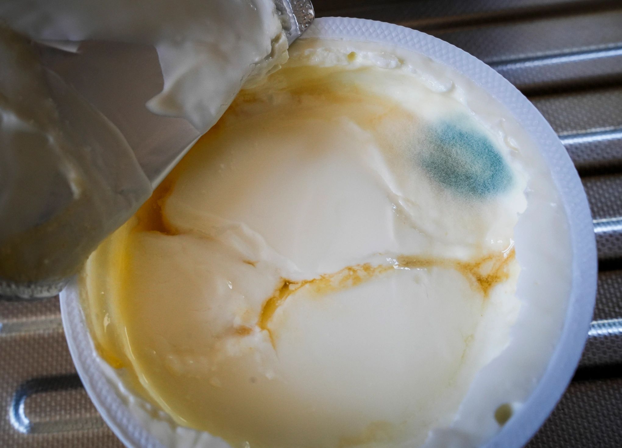 moldy product with separation in a plastic tub. this was a consumer packaged good that has spoiled