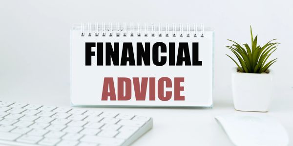 Sign reading Financial Advice next to keyboard and plant.