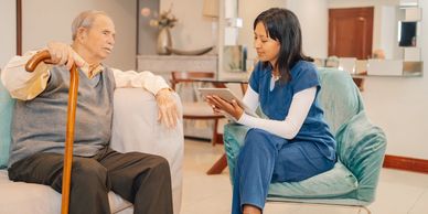 A healthcare worker consulting with an elderly man at home.