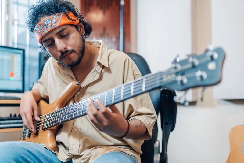 Musician playing the electric guitar in the recording studio at home
