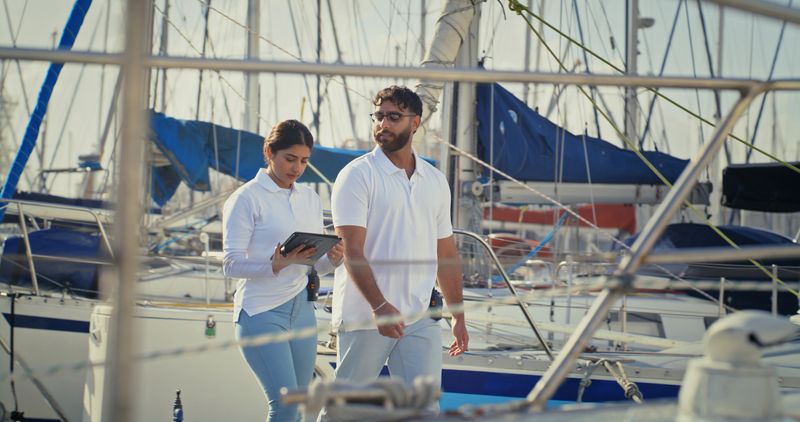 Collaboration, tablet and cabin crew with people on boat for luxury holiday, digital checklist and maritime safety. Captain, sailor and marina with man and woman on yacht for app, nautical and harbor