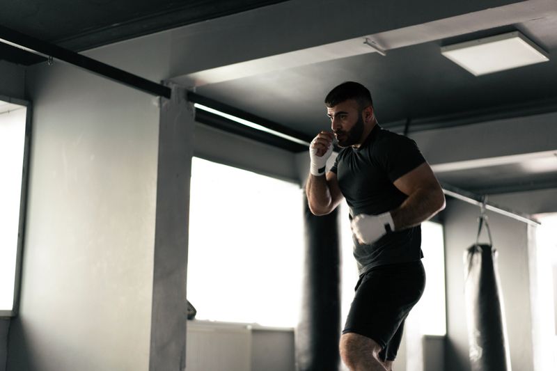 Boxer man doing shadow boxing in the gym