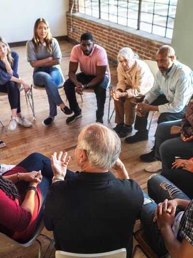 Group therapy session with diverse participants sitting in a circle.