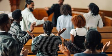 Group of people worshipping in a church.