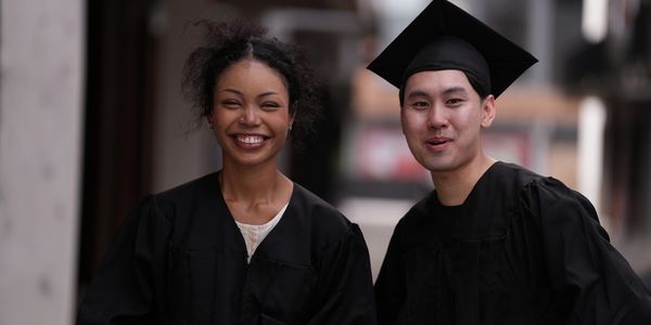 Two happy graduates in caps and gowns.