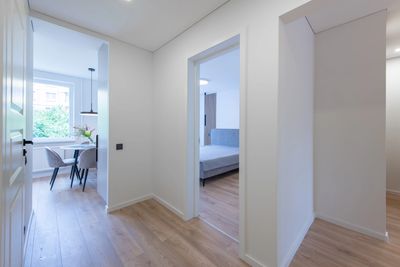 Bright hallway with wooden flooring leading to dining and bedroom areas.