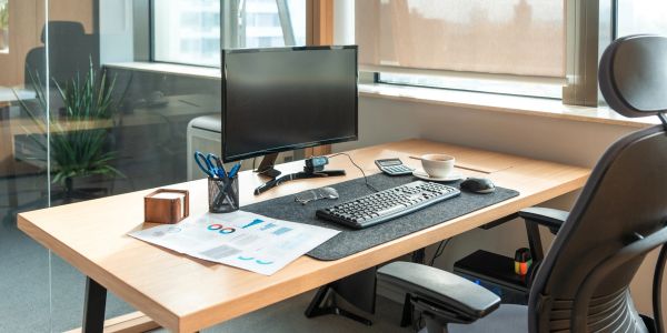 Modern office desk setup with computer and accessories.