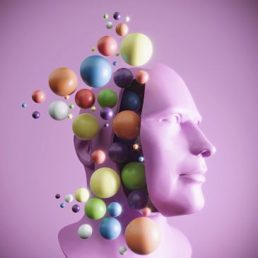 Colorful spheres emerging from a pink human head sculpture.