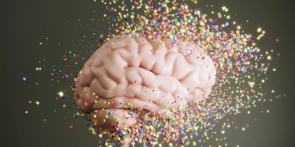 Human brain with colorful particles dispersing from it.