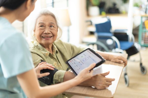 Elderly woman having her blood pressure checked by a nurse.