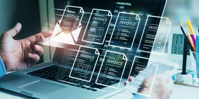 Person managing digital invoices on a laptop and tablet.