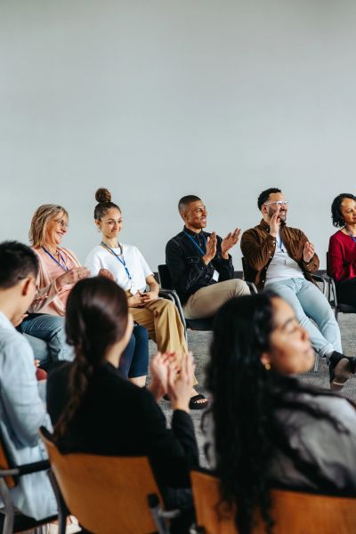A diverse group applauding in a meeting room.