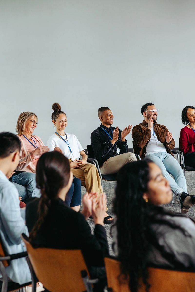 Corporate team engaging in an interactive workshop. A diverse group clapping during a meeting, highlighting teamwork and collaboration.