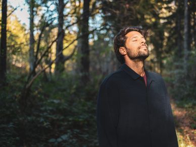 Man peacefully enjoying nature in the forest.