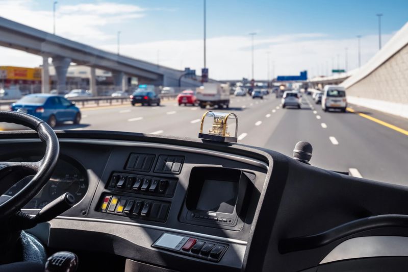 Dubai, UAE. Bus drives along a street metropolis. View through the windshield.