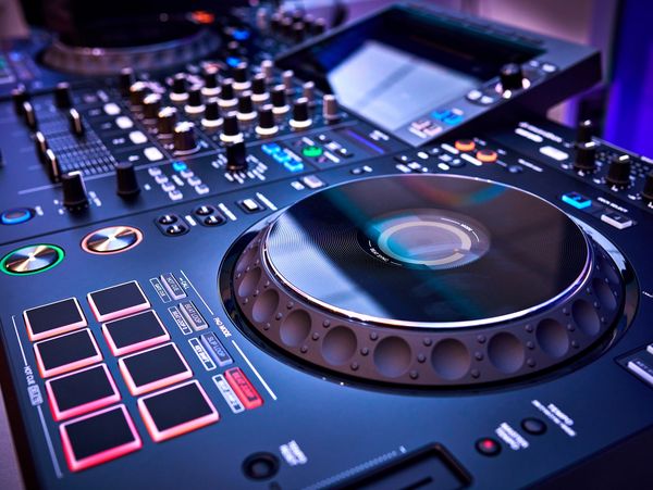 Close-up of a professional DJ controller with illuminated buttons and knobs.