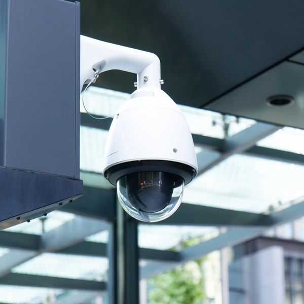 White security camera mounted outdoors.
