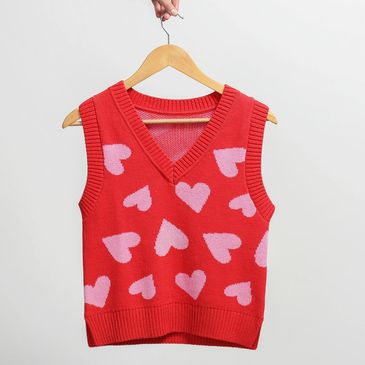 A person holding a sleeveless, cropped sweatshirt