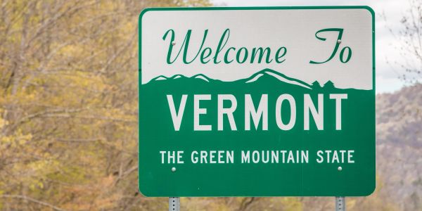 Welcome to Vermont road sign with fall background.