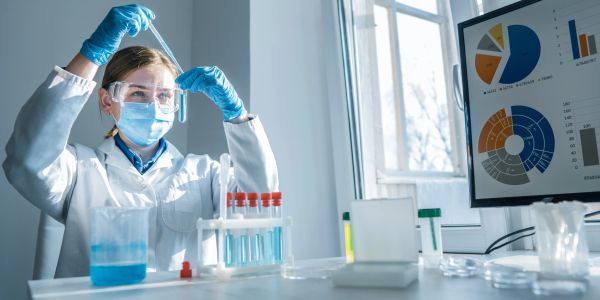 Scientist examining liquid in test tube in a lab.