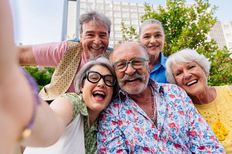 Group of senior friends meeting outdoors in the city and having fun - Cheerful old people bonding together, concepts about elderly, quality of life and aging lifestyle