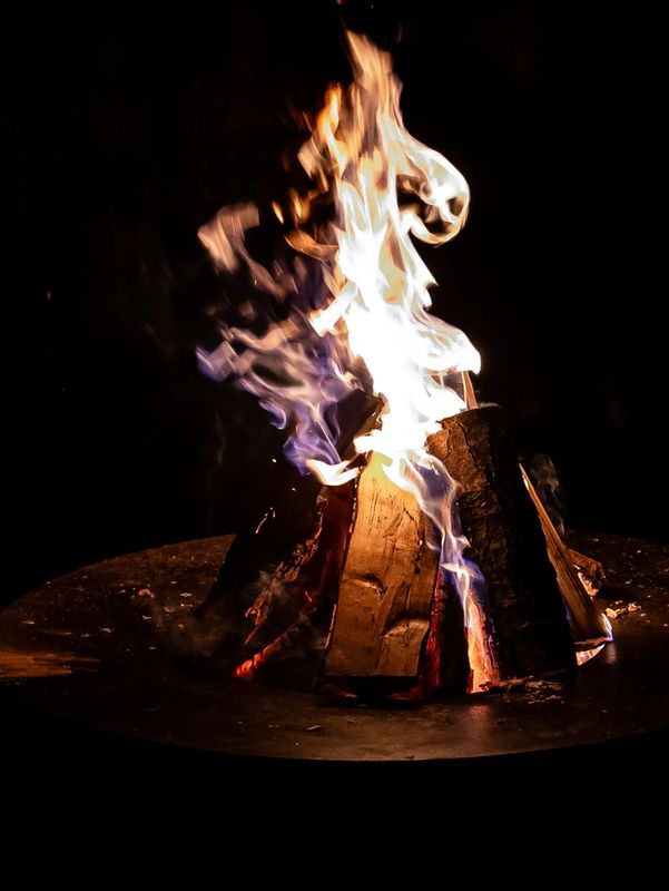 Campfire burning in the dark, showing our work for supporting outdoor recreation 
